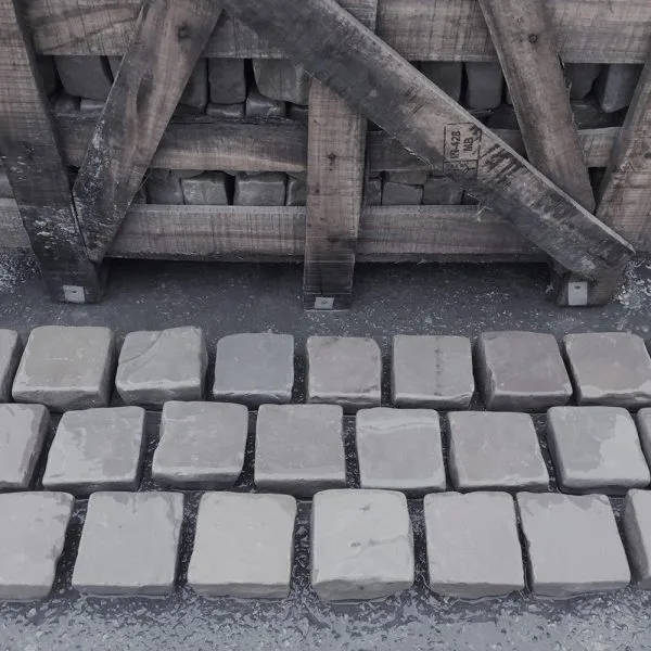 Kandla Grey Tumbled Cobbles 100x100 laid out on the floor in a brick-bond pattern